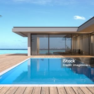 3D render of a single-storey, luxury villa in modern and minimalist architecture.
The villa's floor-to-ceiling windows provide an uninterrupted view of the stunning tropical ocean backdrop.
The villa's private backyard features a swimming pool set within a wooden deck, complete with two loungers for relaxation.