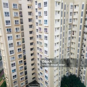High-angle view of beige apartment buildings in Bengaluru, India, showcasing architectural details and surrounding greenery.